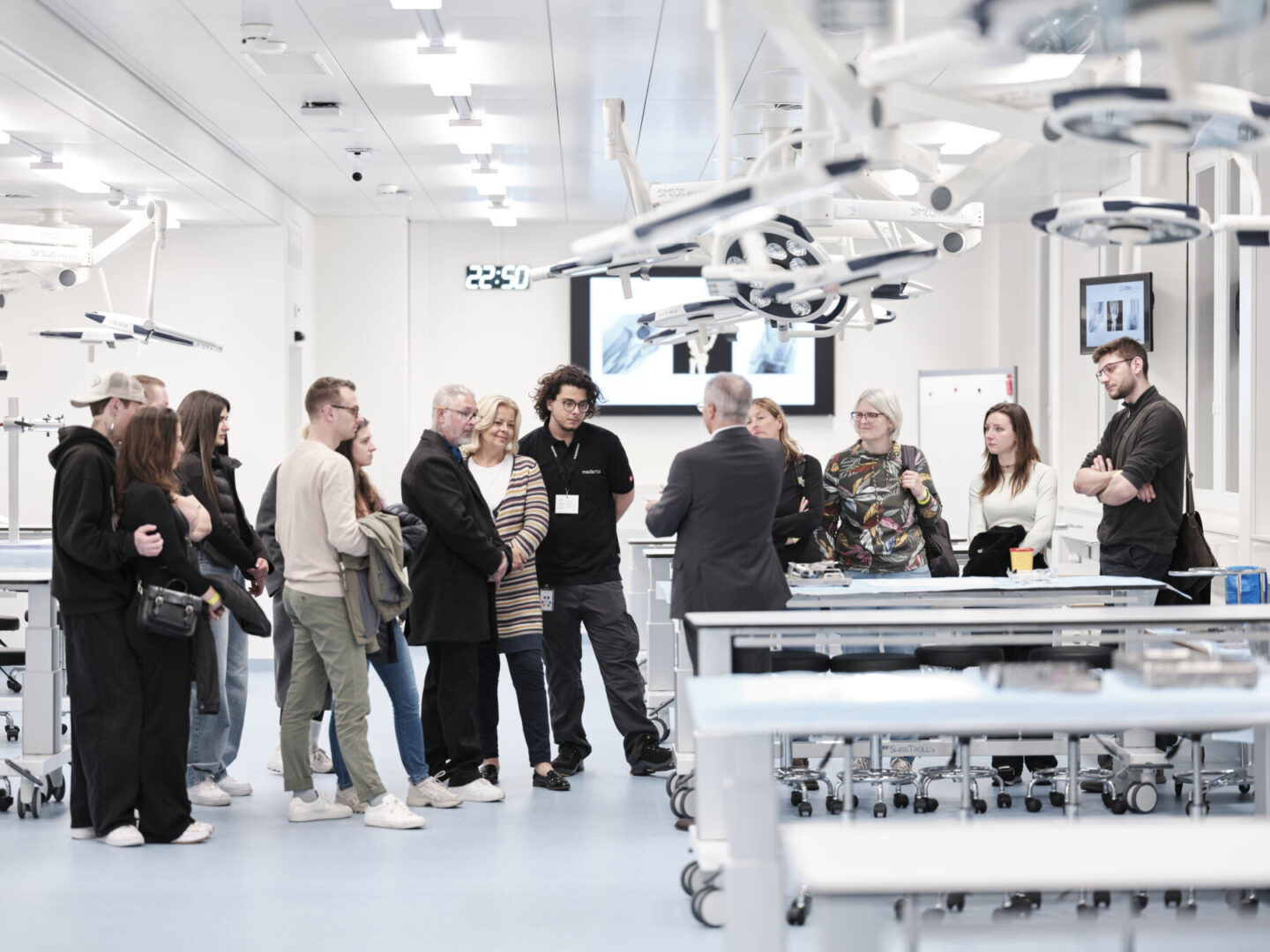 Eine Gruppe von Menschen steht in einem hellen, modernen Operationssaal mit medizinischer Technik.